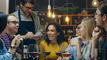 restaurant with group of diners and server