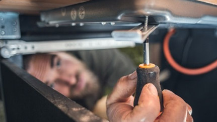 man using screwdriver in a small space