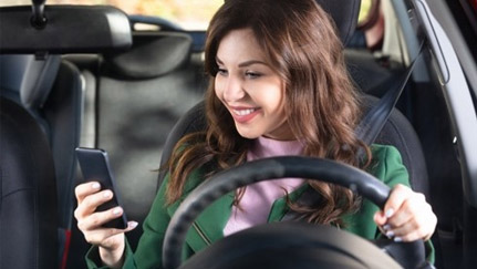 woman in the driver's seat looking at a phone