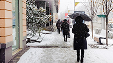 People walking on wet sidewalk with umbrellas